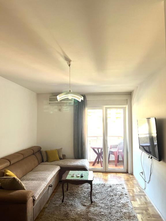 a living room with a couch and a tv at Apartment Tramonto Budva in Budva