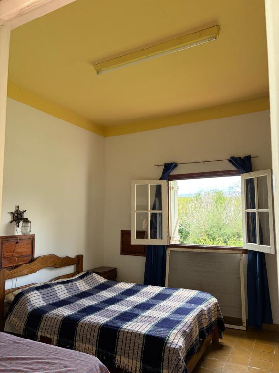 a bedroom with two beds and a window at Habitación con baño privado con cocina separada in Villa Cura Brochero