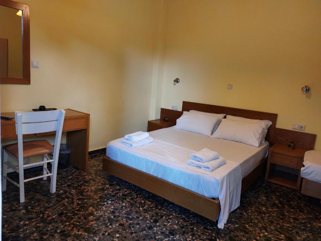 a bedroom with a bed and a desk and a chair at Elafonisos Rooms in Kefálion