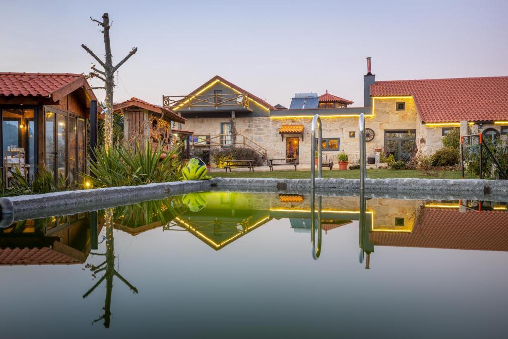 a pool of water in front of a house at Quinta da Eira do Prado in Carvalho