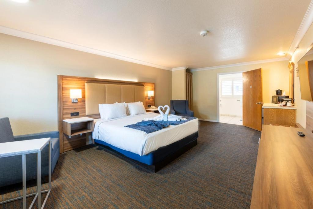 a hotel room with a large bed and a desk at Cayucos Beach Inn in Cayucos