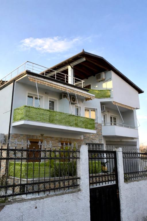 a white house with a gate and a fence at Guest House Vila Krejs in Durrës