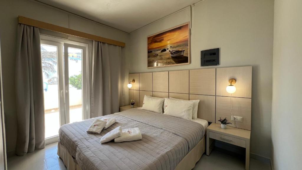 a bedroom with a bed with two towels on it at Thealos in Azolimnos Syros