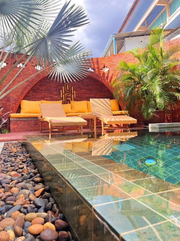 a patio with a pool and chairs and a building at Nine Hotel Chiangmai in Chiang Mai
