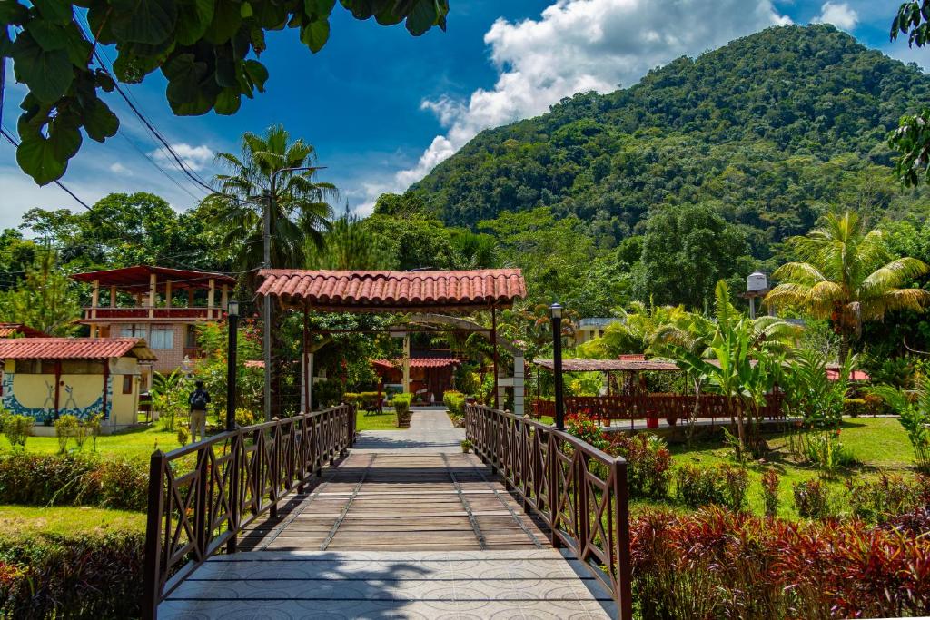 a bridge over a garden with a mountain in the background at Villa Jennifer in Tingo María