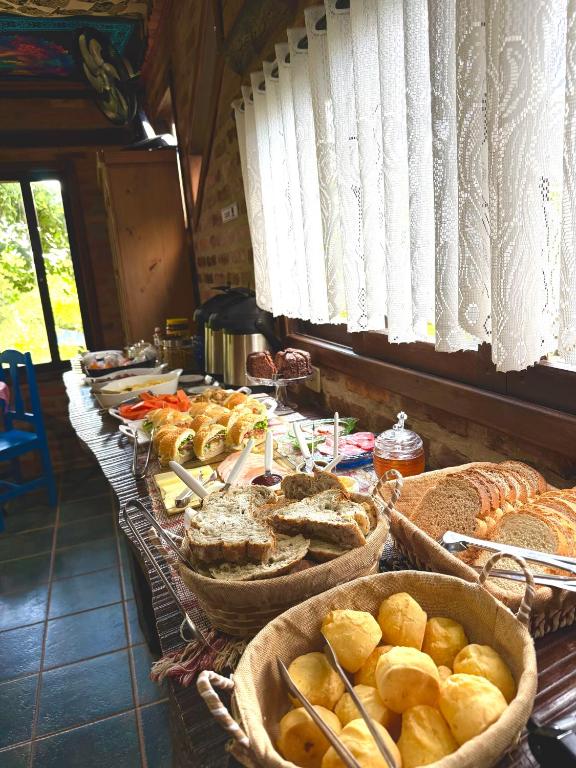 a table filled with bread and baskets of food at Encanto do Mar Praia do Rosa in Praia do Rosa