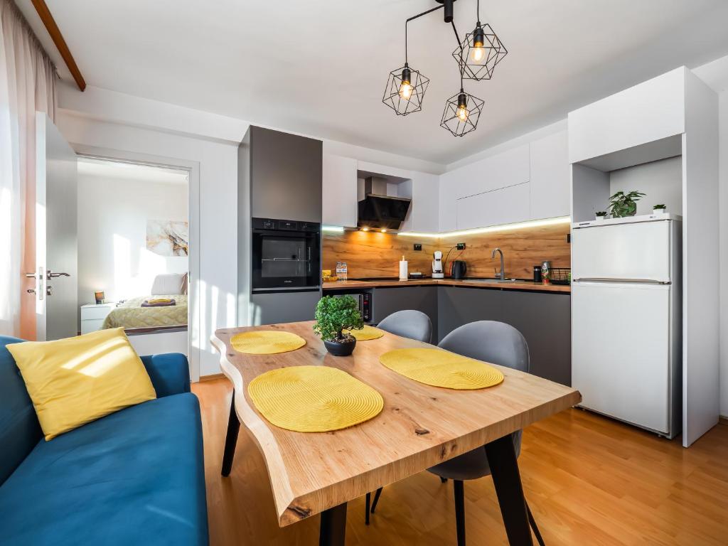 a kitchen and dining room with a wooden table at Прайм, централен апартамент in Pleven