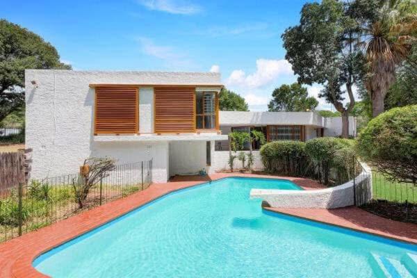 a swimming pool in front of a house at The Wild Side in Sandton