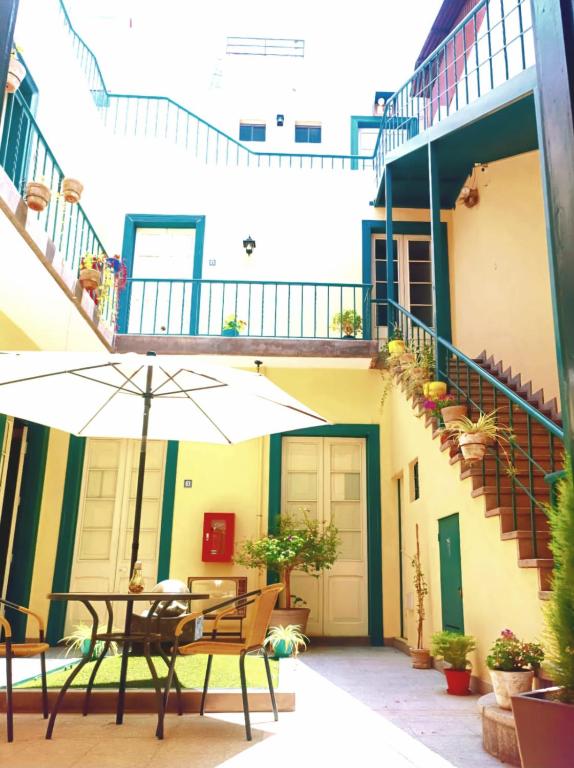 an outdoor patio with a table and an umbrella at Santa Marta Casona in Arequipa