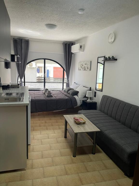 a living room with a couch and a bed and a table at Helios in Ioannina