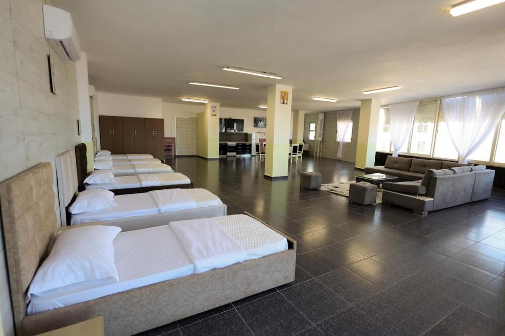 a room with a row of beds and a couch at House Leon in Krujë