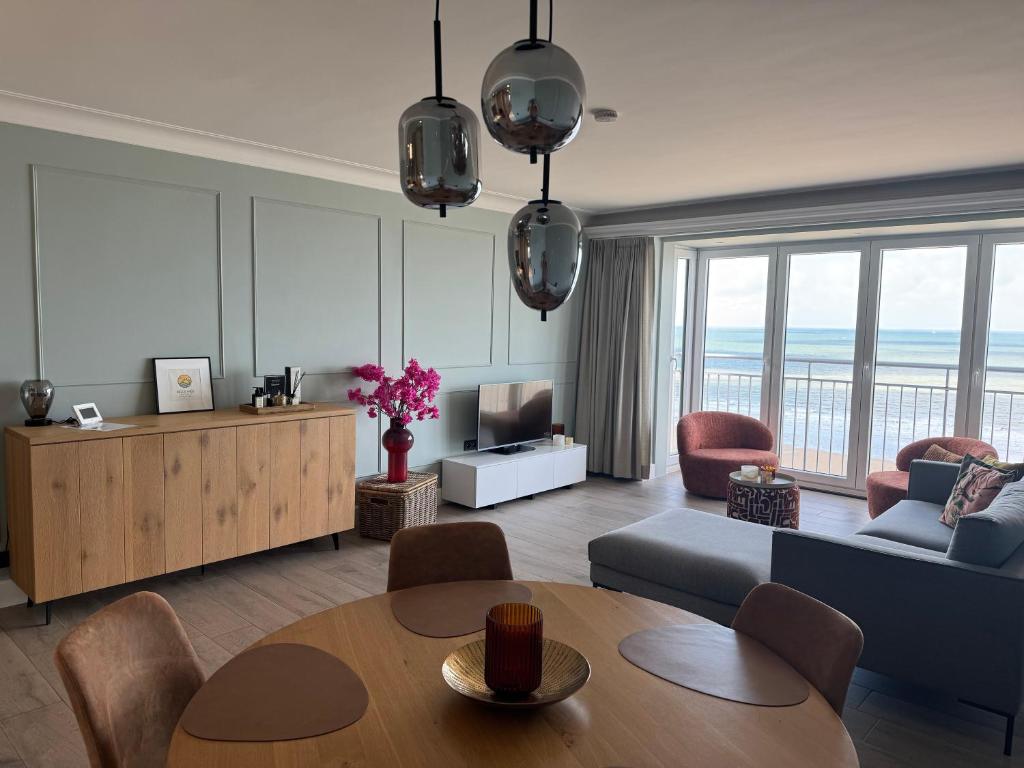a living room with a table and a couch at Sand & Sea - Adults Only in Middelkerke
