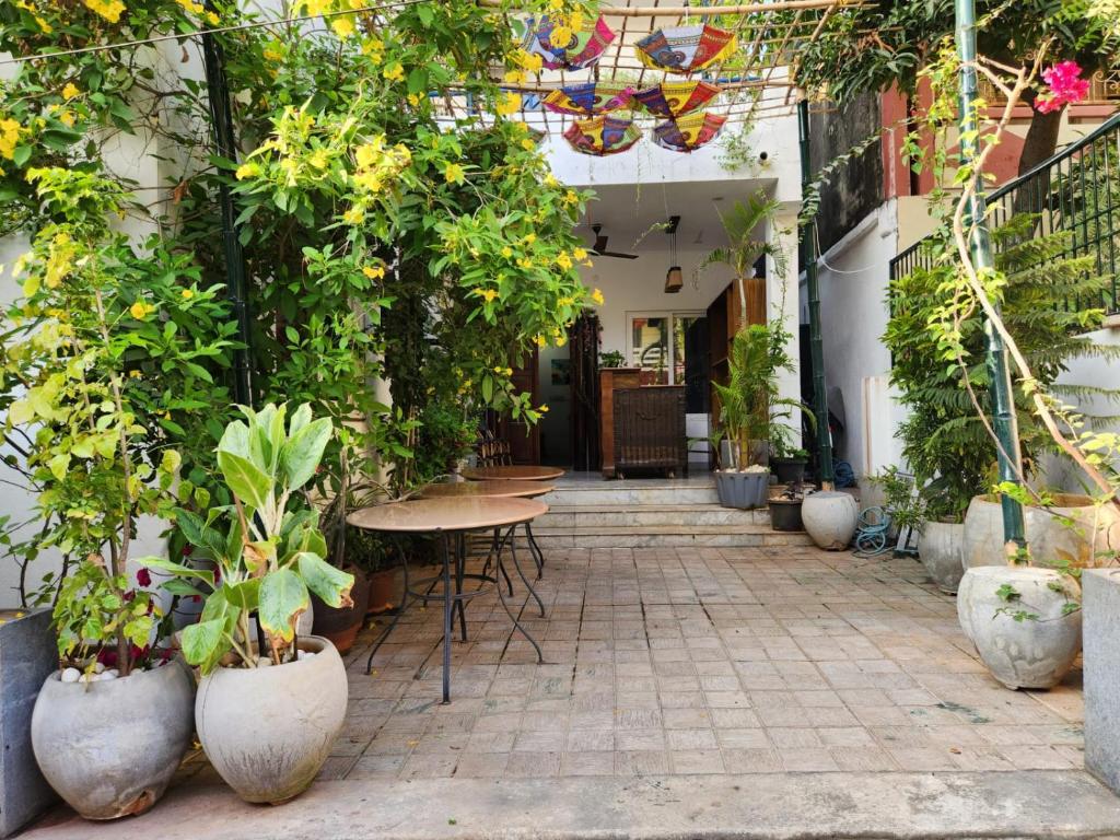 an outdoor patio with tables and potted plants at Garden bay in Pondicherry