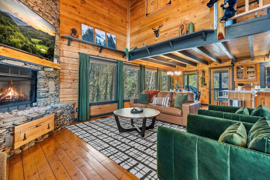 a living room with a couch and a fireplace at Bearfoot Pines - True Log Cabin - Wi-Fi, Hot Tub, Fishing, Deck with views! - Mins to PF in Sevierville
