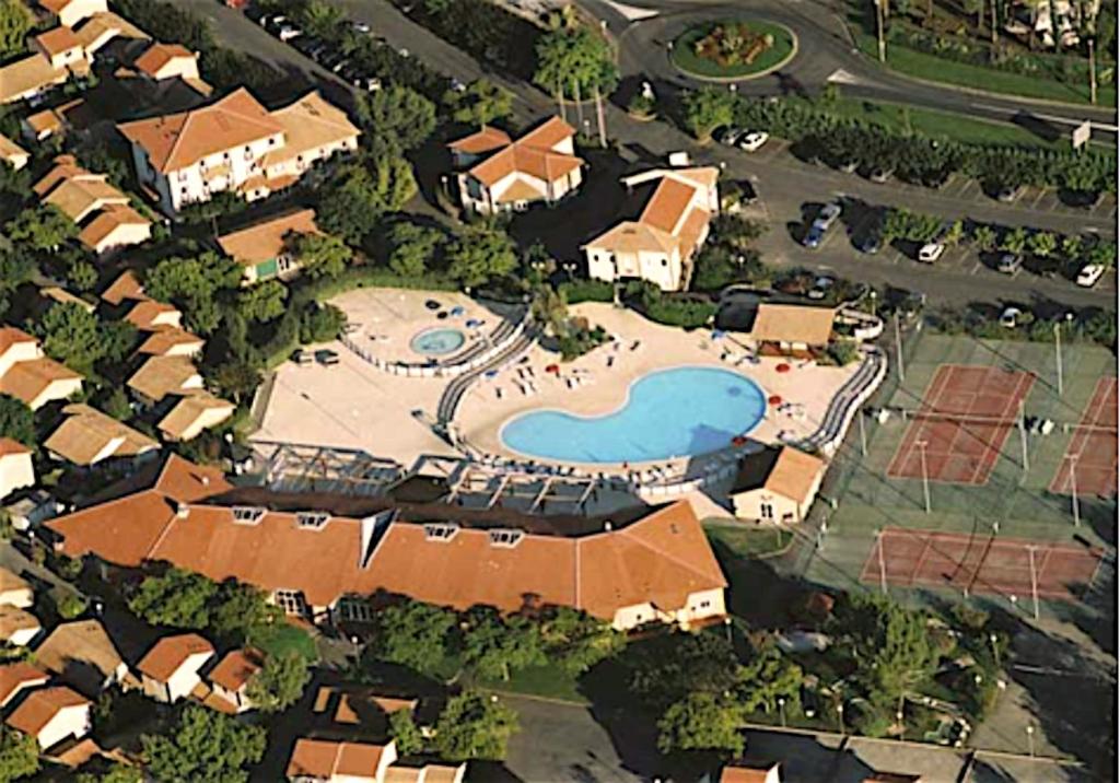 - une vue aérienne sur une maison avec une piscine dans l'établissement Résidence Mes Amours d'Enfants - Les Villas du Lac, à Soustons