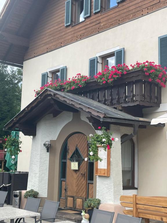 a building with a balcony with flowers on it at Bergbauern Wirtshaus in Kötschach