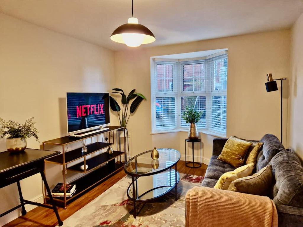 a living room with a couch and a tv at Stylish Spacious Serviced Apartment next to City Centre with Free Parking - Contractors & Relocators in Coventry