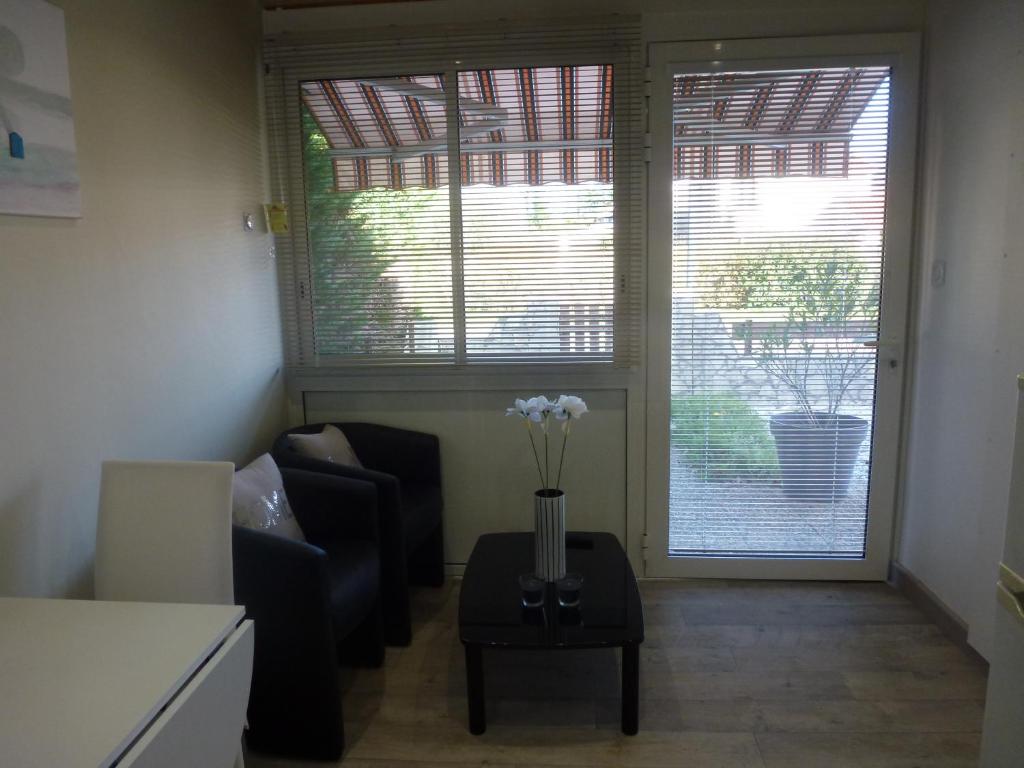 - un salon avec un canapé et une table fleurie dans l'établissement Appartement proche Centre et Arènes, à Dax