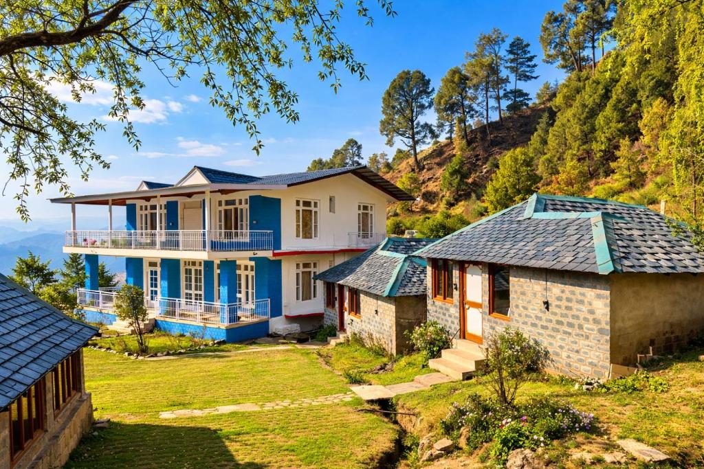 a house on a hill with roofs at Great Himalayan Resort in Dharmsāla
