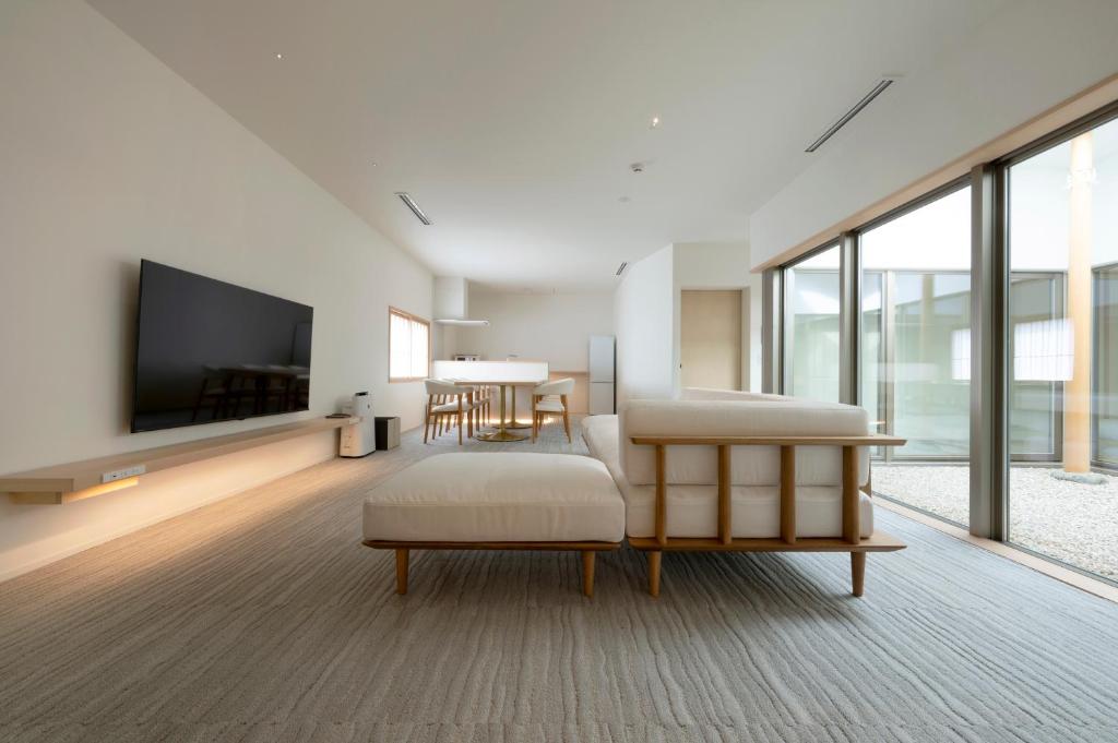 ein Wohnzimmer mit Sofa und Fernseher in der Unterkunft JINRYU Hotel ISE in Ise