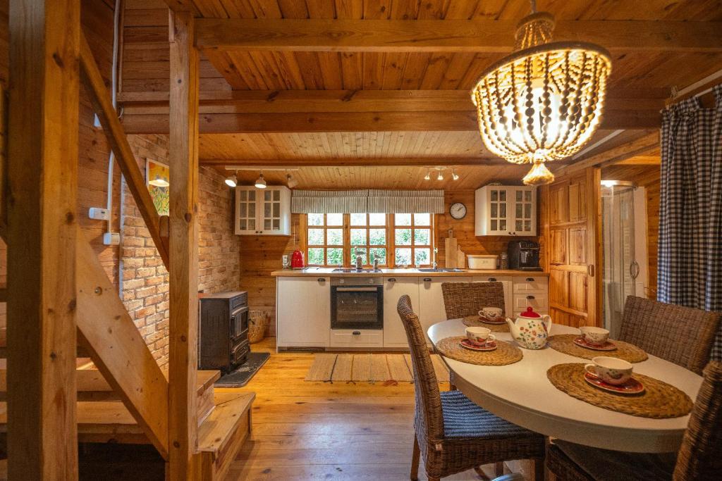 a kitchen and dining room with a table in a cabin at Leśniczówka Białogóra & jacuzzi in Białogóra