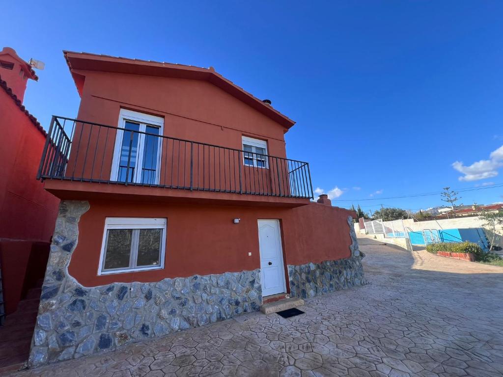 a red house with a balcony on top of it at Casa Latina in Moralet