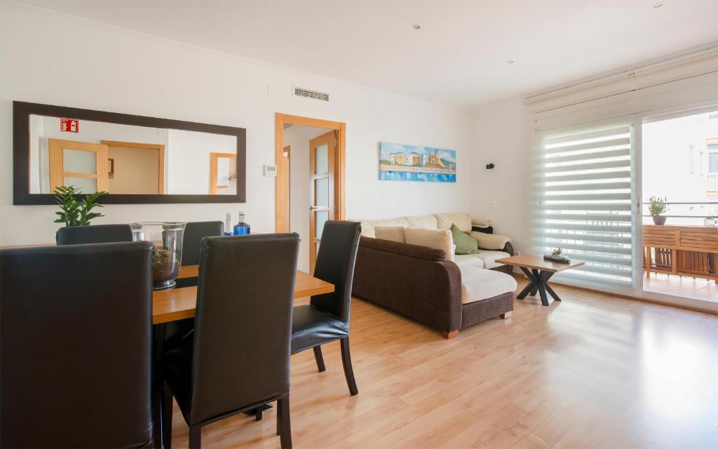 a living room with a table and a couch at BONITO APARTAMENTO in Sitges