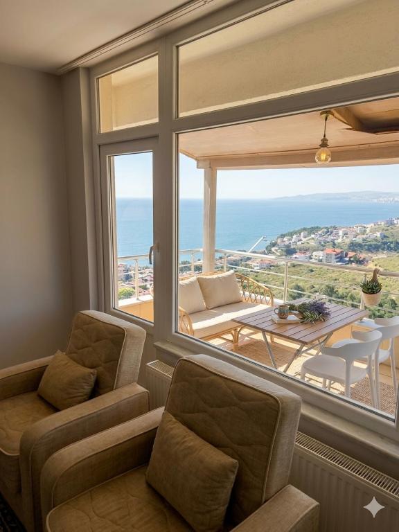 a living room with a large window with a view of the ocean at Karakum Panorama Suites in Sinop