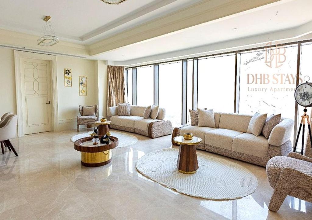 a large living room with couches and tables and windows at The St Regis Luxury in Cairo