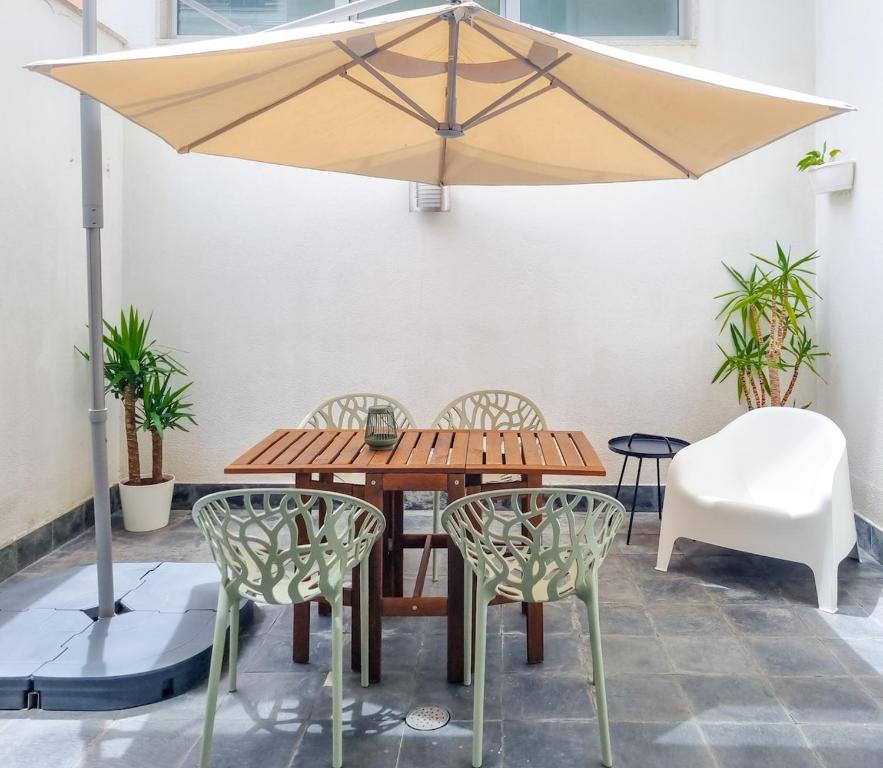 a wooden table and chairs under a large umbrella at Patio by the sea in Cruz Quebrada