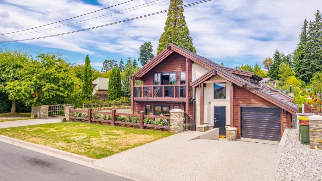 a house with a garage and a fence at Mountain View Chalet in Wanaka