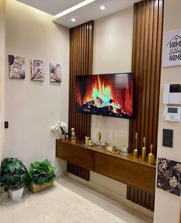 a living room with a tv on a wall at Tokyo in Maarif