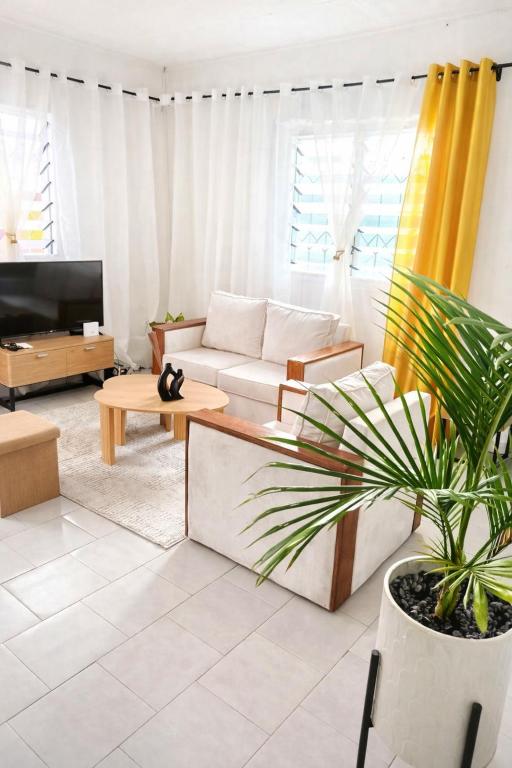 a living room with a couch and a potted plant at Côté Plage Kribi Studio Soleil in Kribi