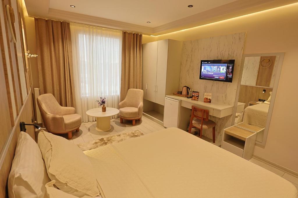 a hotel room with a bed and a television at Lavender Inn Hotel in Arnavutköy