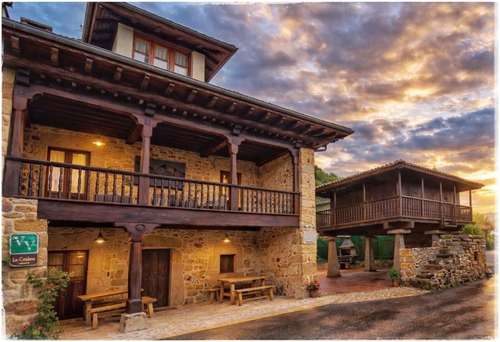 a large building with a balcony and a picnic table at Los Campos Vivienda Vacacional in Cangas de Onís
