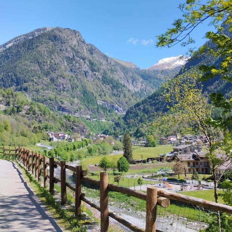 a bridge over a river with mountains in the background at Appartamento Verdenatura in Branzi
