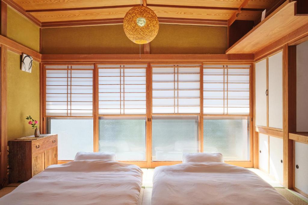 two beds in a room with a large window at nouveau marche ヌーボーマルシェ in Katori