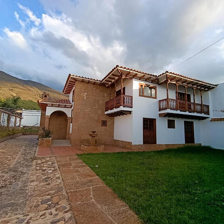 a house with two balconies and a yard at Hotel Boutique Villa Amonita in Villa de Leyva