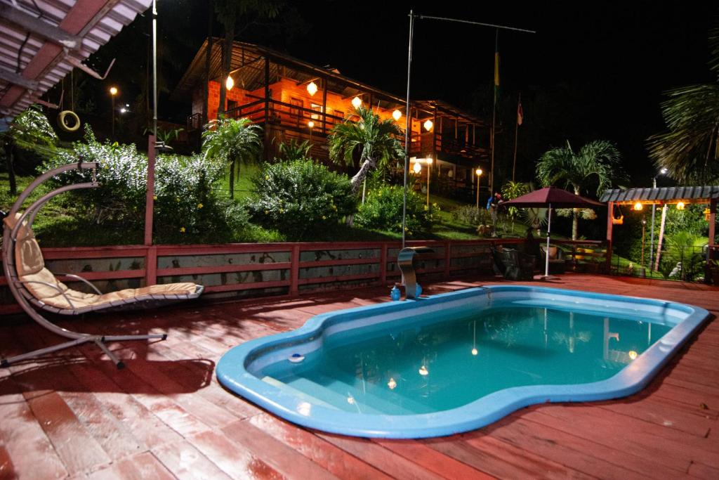 a swimming pool on a wooden deck at night at Angatu Amazon Jungle Lodge in Iranduba
