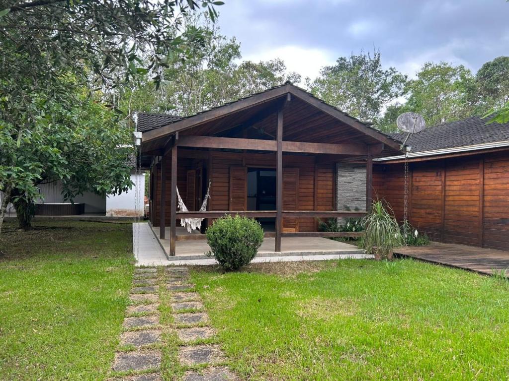 a wooden house with a lawn in front of it at Quintal da Serra in Morretes