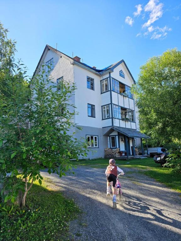 a woman and child walking down a road in front of a house at Gamlevegen in Fagernes