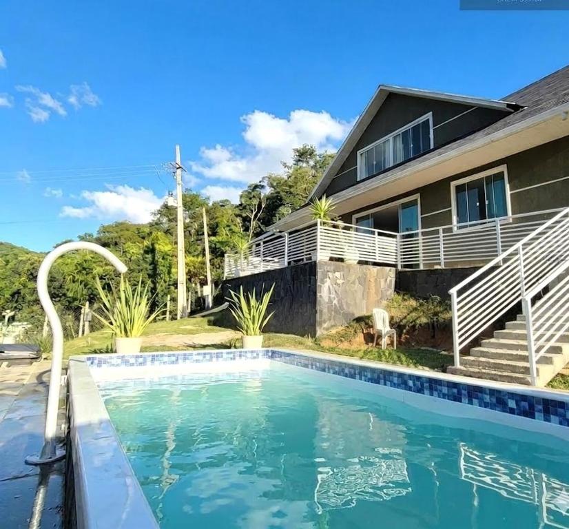 a house with a swimming pool in front of a house at Casa da Colina Curitiba com piscina in Curitiba