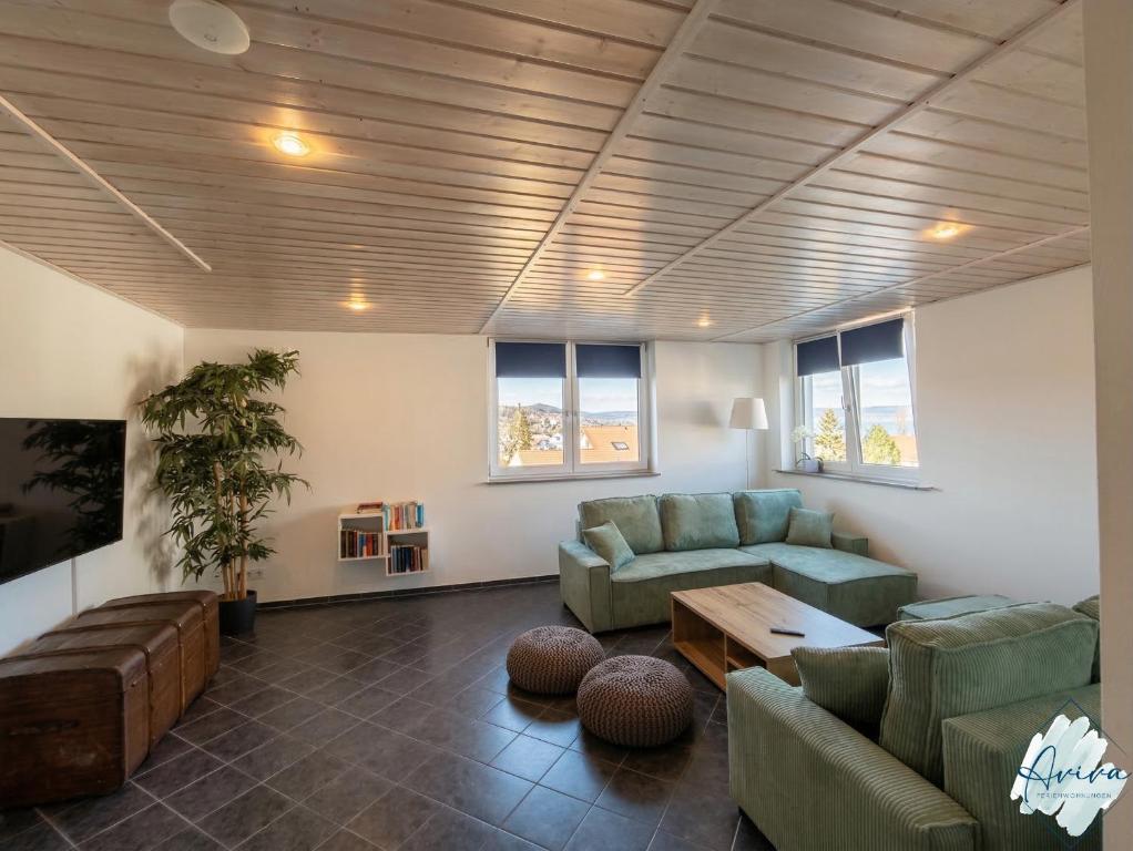 a living room with two couches and a table at Aviva SEEPANORAMA - Großzügige 85m Wohnung mit Bodenseeblick in Bodman-Ludwigshafen