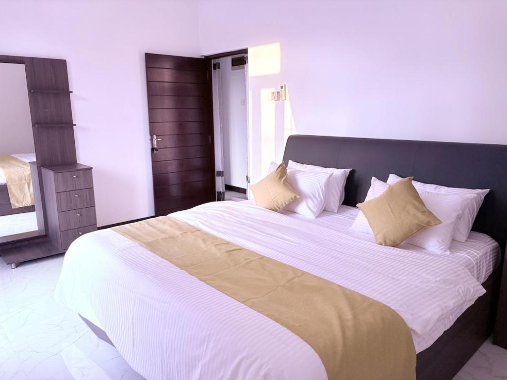 a bedroom with a large bed with white sheets and pillows at Edelweiss Living Negombo in Negombo
