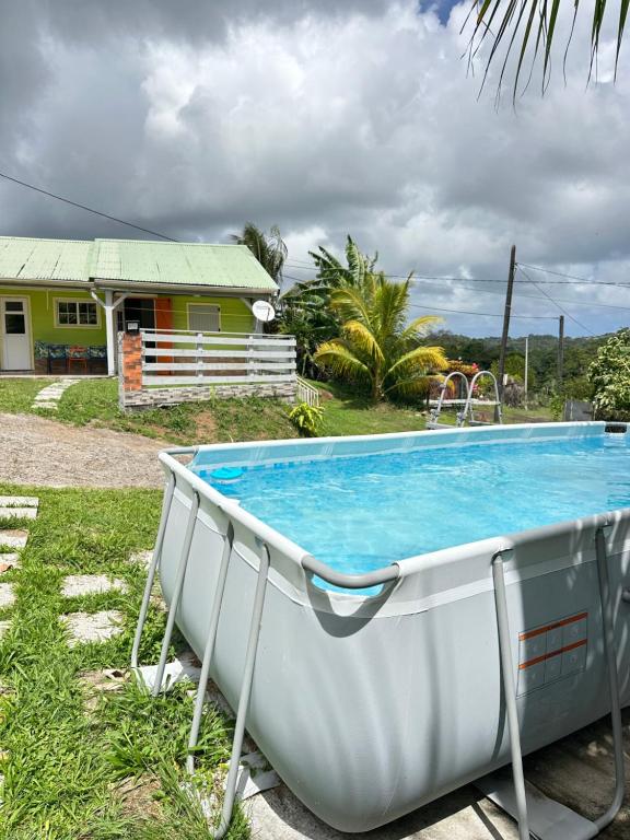a white boat sitting in the grass next to a house at L'île au Vert in Gros-Morne