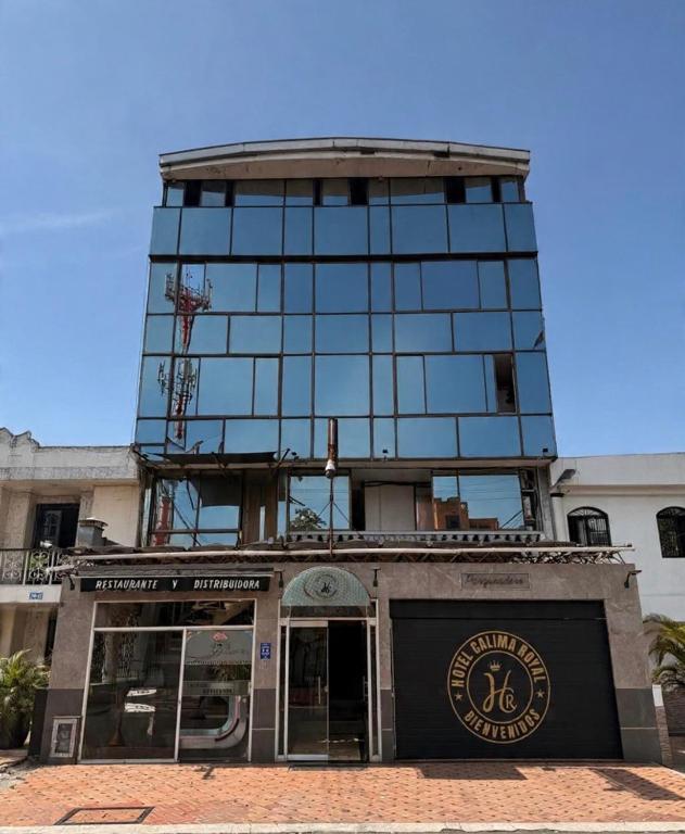 a tall glass building with a store in front of it at Hotel calima royal in Cali