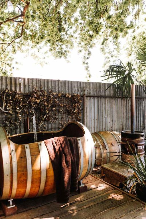 a row of wine barrels sitting next to a fence at Ateliers Den in Beechworth