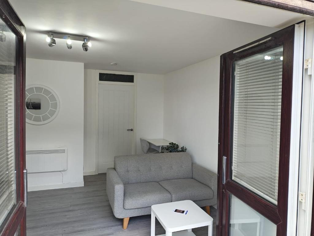 a living room with a couch and a table at Thames Riverside Studio, Gravesend Town Centre - near train station in Gravesend