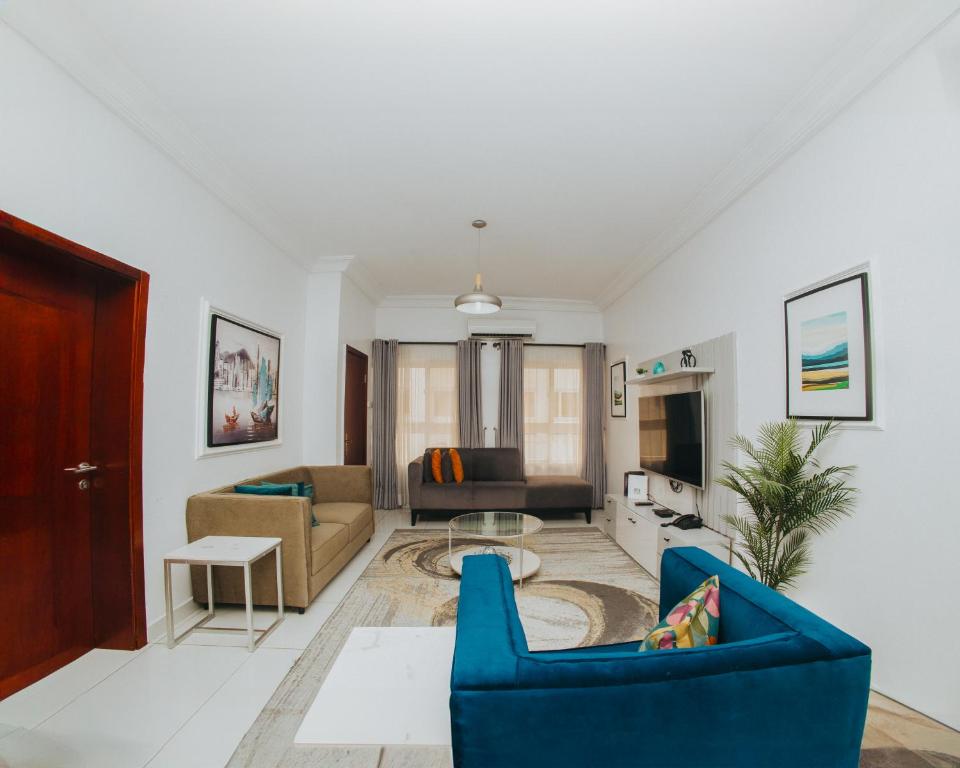 a living room with a blue couch and a table at AvonHeights Apartments in Lekki Phase 1