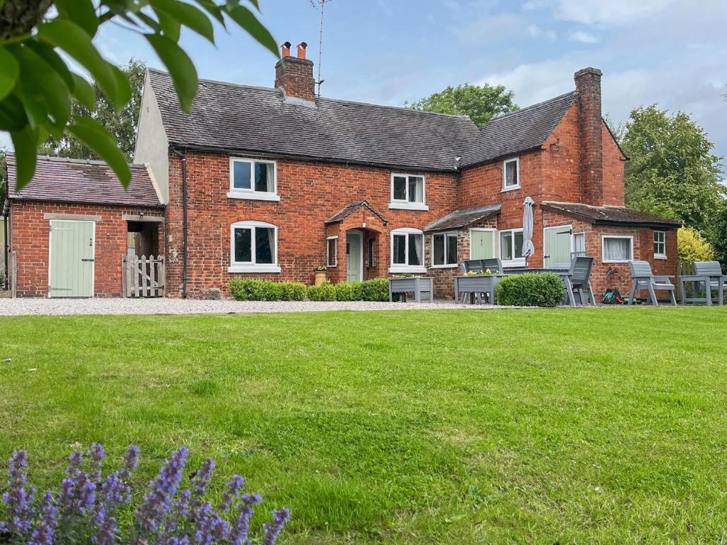 a brick house with a lawn in front of it at Brynfields in Ashbourne
